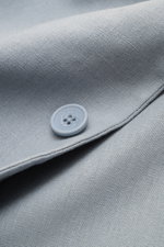 Nahaufnahme des rauchblauen Percival Sakko 'Tailored Linen' aus atmungsaktivem Leinen-Baumwoll-Mix mit Slim Fit, fallendem Revers und Knopfdetails.