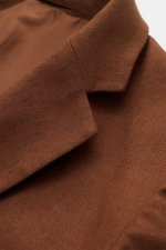 Nahaufnahme des fallenden Reverses vom Percival Sakko 'Tailored Linen' braun aus atmungsaktivem Leinen-Baumwoll-Mix, leicht griffig.