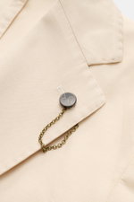 Nahaufnahme des fallenden Revers mit Label-Pin des Santaniello Sakko creme in Slim Fit aus Baumwolle, Leinen und Mohair.