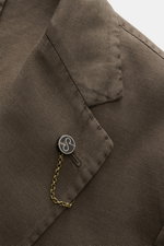 Nahaufnahme des fallenden Revers mit Label-Pin und Kissing Button am Santaniello Sakko dunkelbraun aus Baumwoll-Mix, slim fit.
