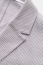 Nahaufnahme des Harris Wharf London Seersucker-Blazer grau/weiß gestreift, sportiver Slim Fit aus Baumwoll-Mix mit fallendem Revers und klassischer Brusttasche, fotografiert von oben.