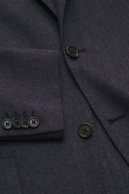 Close-up front view of the Corneliani Blazer grey pattern showing tonal fine herringbone silk-cashmere blend fabric, soft touch, slim fit two-button style with notched lapel, classic breast pocket, patch hip pockets, kissing buttons, rear side vents, unco