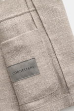 Nahaufnahme des Corneliani Sakko grau/hellbraun meliert aus Schurwoll-Seiden-Baumwoll-Mix mit melierter Webstruktur, klassischer Brusttasche und Label, fotografiert aus schräger Vogelperspektive.