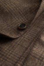 Corneliani Sakko graubraun kariert, Nahaufnahme eines Knopfs und fallendem Revers, feiner Wolle-Cashmere-Mix, tonales Prince-of-Wales-Muster.