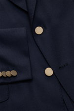 Nahaufnahme aus schräger Perspektive des Boglioli Sakko 'K. Jacket' navy mit goldfarbenen Kissing Buttons, reiner Wolle, Leinwandbindung, Slim Fit, Zwei-Knopf-Stil, Spitzrevers, Brusttasche, Hüfttaschen mit Patte, rückwärtigen Seitenschlitzen und Unconstr