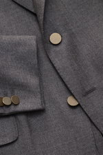 Nahaufnahme des Boglioli Sakko 'K. Jacket' graubraun meliert, Front links mit tailliertem Zwei-Knopf-Stil, Spitzrevers, Slim Fit, reiner Wolle mit markanter Leinwandbindung, Kissing Buttons und klassischer Brusttasche, fotografiert aus schräger Draufsicht
