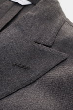 Nahaufnahme des Boglioli Sakko 'K. Jacket' graubraun meliert mit strukturierter Leinwandbindung, Spitzrevers und Brusttasche, fotografiert von schräg oben.