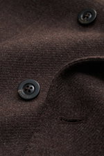 Nahaufnahme des dunkelbraunen Boglioli Sakko 'K. Jacket' mit feinem Strukturgewebe, zwei schwarzen Kissing Buttons und Unconstructed Design, Fokus auf Wolle-Cashmere-Mix aus schräger Perspektive.