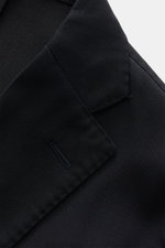 Nahaufnahme des Boglioli Sakko dark navy von schräg oben, reine Schurwolle, softer Griff, feiner tonaler Fischgrat, Slim Fit, taillierter Zwei-Knopf-Stil, fallendes Revers, klassische Brusttasche, aufgesetzte Hüfttaschen, Kissing Buttons, rückwärtige Seit