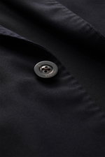 Nahaufnahme des Boglioli Sakko dark navy mit Fokus auf Knopf und feinem, tonalem Fischgrat aus reiner Schurwolle, softer Griff, Slim Fit, taillierter Zwei-Knopf-Stil.