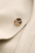 Close-up front view of the Boglioli Beige Melange Knit Blazer showing a tortoiseshell button on a soft silk-cashmere blend knit fabric with fine texture.

Description: <p>Exquisite knit blazer by BOGLIOLI: Crafted from a luxurious silk-cashmere blend with