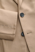 Nahaufnahme aus seitlicher Perspektive des Tom Ford Sakkos 'Shelton' beige mit feiner Twillstruktur, zwei Knöpfen und weichem Woll-Seide-Mix.