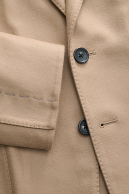 Nahaufnahme aus seitlicher Perspektive des Tom Ford Sakkos 'Shelton' beige mit feiner Twillstruktur, zwei Knöpfen und weichem Woll-Seide-Mix.