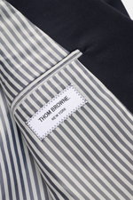 Innenansicht mit gestreiftem Futter und Thom Browne Label des maritim monochromen Thom Browne Sakko navy aus reiner Wolle.
