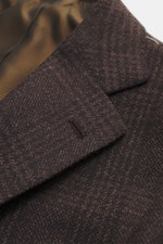 Close-up angled view of Cesare Attolini Cashmere Blazer dark brown/black checkered showing the notched lapel and classic breast pocket, made of pure cashmere with a soft touch and Glen check pattern, tailored slim fit with three-button style, patch hip po