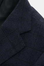 Close-up front angled view of the Cesare Attolini Navy/Black Checked Blazer featuring a mix of wool and cashmere, soft touch, classic Glencheck pattern, Slim Fit, tailored three-button style, notched lapel, classic breast pocket, patch hip pockets, unfini