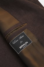 Close-up inside view of the Cesare Attolini Cashmere Blazer Dark Brown Mélange showing fine brown mélange cashmere fabric, striped brown lining, inner pocket, and stitched label. Indulge in luxury from CESARE ATTOLINI: This timeless blazer is made in Ital