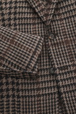 Close-up front view of Stile Latino Blazer 'Vincenzo' taupe/black checkered with coarse houndstooth weave, wool-alpaca-silk blend, three buttons, notched lapel, and patch pockets. The classic blazer 'Vincenzo' by STILE LATINO imparts a distinctly Italian 