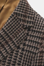 Close-up photo from above of the Stile Latino Blazer 'Vincenzo' taupe/black checkered showing its coarse houndstooth weave fabric and golden-brown silk lining. The classic blazer 'Vincenzo' by STILE LATINO imparts a distinctly Italian character: the fabri