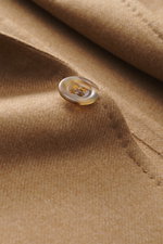 Close-up, angled top-down view of a beige melange button on the Stile Latino Blazer 'Vincenzo' made from virgin wool and cashmere blend.