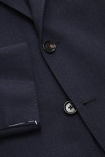 Close-up front view of the Borrelli Blazer 'Procida' grey blue showing slim fit, tonal subtle herringbone, three-button style, notched lapel, classic chest pocket, patch hip pockets, unfinished sleeve ends, rear side vents, half lined, two inside pockets,