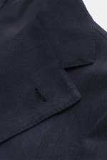 Close-up front perspective of Borrelli Blazer 'Procida' grey blue showing tonal, subtle herringbone fabric, notched lapel, and buttonhole, made of a mix of virgin wool and cashmere with a soft feel, Slim Fit, tailored three-button style, classic chest poc