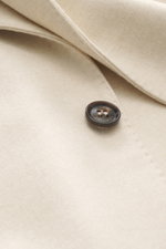 Close-up front view of the Colombo Kid Cashmere Blazer 'Robert' cream showing soft Yangir Cashmere fabric and branded button detail.

Description: In the ultra-light quality of soft Yangir Cashmere, the unconstructed blazer 'Robert' by COLOMBO is a luxuri