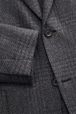 Close-up front view of Lardini Blazer dark grey melange showing wool, microfiber, cotton mix, soft feel, airy woven structure, subtle tonal Glencheck, slim fit, fitted two-button style, notched lapel with flower pin, classic breast pocket, patch hip pocke