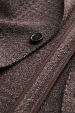 Close-up top view of the Lardini Blazer grey-brown melange showing a button, soft wool, microfiber and cotton mix, subtle tonal Glencheck, soft feel, airy woven structure, slim fit, fitted two-button style, notched lapel with flower pin, classic breast po