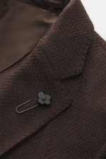 Close-up top-down view of the Lardini Blazer dark brown showing its airy Panama weave mix of cashmere and silk, soft touch, slim fit, dropped lapel with flower pin, tailored two-button style, classic breast pocket, patch hip pockets, unfinished sleeve cuf