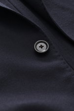 Nahaufnahme des Lardini Jersey-Sakko navy, perspektivisch von schräg oben, Jersey aus reiner Schurwolle, softer Griff, Slim Fit, taillierter Zwei-Knopf-Stil, fallendes Revers mit Blüten-Anstecker, klassische Brusttasche, Hüfttaschen mit Patte, Ärmelabschl