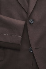 Close-up front view of Lardini Brown Jersey Blazer showcasing slim fit, two-button tailored style, notched lapel with flower pin, classic breast pocket, hip flap pockets, unfinished sleeve cuffs, rear vents, unconstructed design, made of soft pure virgin 