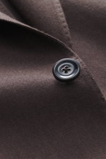 Close-up front angle of Lardini Brown Jersey Blazer showcasing a black four-hole button on pure virgin wool jersey fabric with soft touch, slim fit, tailored two-button style, notched lapel with flower pin, classic breast pocket, hip pockets with flap, un