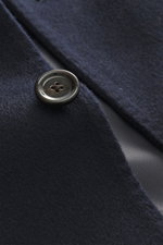 Close-up front view of the Lardini Cashmere blazer navy showing a black button on pure cashmere fabric with soft touch, slim fit, stand-up collar with tab, tailored four-button style, patch hip pockets, buttoned sleeve cuffs, center back vent, unconstruct