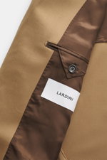 Close-up inside view of the Lardini Blazer light brown showing gabardine fabric, smooth feel, slim fit, notch lapel, double-breasted two-button style, classic breast pocket, hip pockets with flap, unfinished sleeve cuffs, rear side vents, half lined, and 