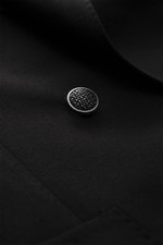 Close-up of the Tagliatore Black Blazer's black textured button and fabric from a macro perspective, highlighting fine wool texture.

<p>The double-breasted blazer by TAGLIATORE made of pure new wool combines Italian tailoring craftsmanship with contempor