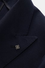 Close-up front-side view of the Tagliatore Blazer navy showing pure virgin wool fabric with a slightly textured feel, peak lapels, and brand-typical pin.

<p>The double-breasted blazer by TAGLIATORE made of pure virgin wool combines Italian tailoring with