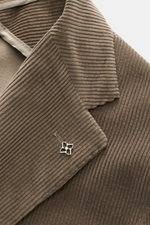 Close-up front view of the Tagliatore Cord Blazer taupe showing soft cotton-wool corduroy fabric, notched lapel with brand pin, and fine ribbed texture. The unconstructed design makes this slim fit blazer an exclusive office companion, featuring a fitted 