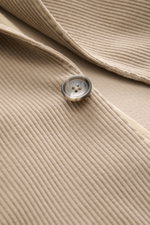 Close-up front view of the Tagliatore Cord Blazer beige, showing soft cotton-wool corduroy, a two-button style with a notched lapel and a brand pin. The unconstructed design features a classic breast pocket, patch hip pockets, unfinished sleeve cuffs, rea