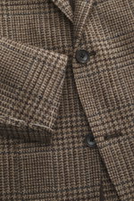 Nahaufnahme des Tagliatore Sakkos dunkelgrau/taupe kariert von vorne schräg oben, Slim Fit, Prince-of-Wales Muster, weicher Griff, zwei Knöpfe, fallendes Revers, Brust- und Hüfttaschen sichtbar.