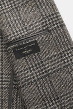 Tagliatore Blazer grey/black checked close-up from the inner side showing fabric label, mix of virgin wool and cashmere, soft touch, Prince of Wales pattern, slim fit, tailored two-button style, notched lapel, brand-typical pin on the lapel, classic breas