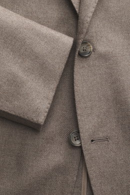Close-up frontal view of the Tagliatore Blazer taupe showing wool with cashmere content, soft touch, slim fit, tailored two-button style, notched lapel with brand-typical pin, classic breast pocket, patch hip pockets, unfinished sleeve cuffs, back side ve