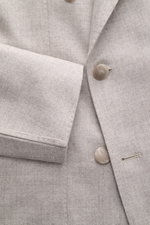 Close-up front view of the Tagliatore Taupe Melange Blazer showcasing its soft virgin wool-cashmere blend fabric, double-breasted three-button style, peaked lapel with signature pin, classic breast pocket, and unfinished sleeve cuffs. Italian tailoring at