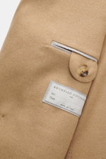 Close-up detail of the Brunello Cucinelli Camel Hair Blazer camel, photographed from the front showing pure camel hair fabric, very soft touch, Slim Fit, double-breasted three-button style, peak lapel, classic breast pocket, hip pockets with flap, small t