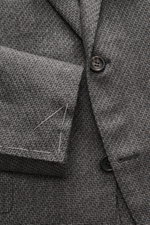 Close-up front view of Canali Blazer grey patterned showing pure wool fabric with distinctive woven pattern, soft touch, slim fit, tailored two-button style, notched lapel, classic breast pocket, hip pockets with flap, sleeve ends unfinished, rear side ve