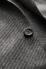 Close-up front view of the Canali Blazer grey patterned showing pure wool fabric with a distinctive woven pattern and soft touch, featuring a slim fit, tailored two-button style, notched lapel, classic breast pocket, hip pockets with flap, sleeve ends unf