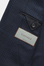 Close-up view of the Canali Blazer navy/black checked fabric showing pure wool, Prince-of-Wales pattern, soft touch, slim fit, tailored two-button style, notched lapel, classic breast pocket, hip pockets with flap, unfinished sleeve cuffs, rear side vents