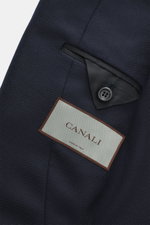 Close-up front-side view of Canali Blazer navy showing wool with silk fabric, tonal woven pattern, soft touch, slim fit, tailored two-button style, notched lapel, classic breast pocket, hip pockets with flap, unfinished sleeve cuffs, rear side vents, unco
