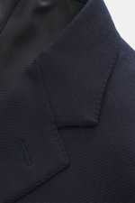 Close-up, angled top view of Canali Blazer navy showing wool with silk fabric, tonal woven pattern, soft touch, slim fit, tailored two-button style with notched lapel, classic breast pocket, hip pockets with flap, unfinished sleeve cuffs, rear side vents,