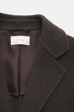 Close-up, top-front view of The Row Cashmere Blouson 'Olek' schwarz showing its soft, dense black cashmere collar and inner lining, highlighting meisterhafte Handwerkskunst in doppelter Verarbeitung with reiner Cashmere, weicher Griff, Zwei-Wege-Reißversc